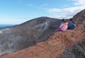 Girl and boy sitting on the rim of volcano crater Royalty Free Stock Photo