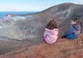 Girl and boy sitting on the rim of volcano crater Royalty Free Stock Photo