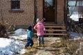 A girl and boy stand at the porch of house and play with soap bubbles Royalty Free Stock Photo