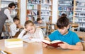 Girl and boy studying in school library Royalty Free Stock Photo