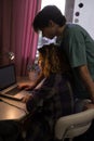 girl and boy teenagers 16-17 years old, high school students study together at a laptop by the light of a table lamp Royalty Free Stock Photo