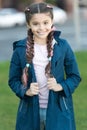 Girl with braided hair style with pink kanekalon. Add bright detail. Little girl with cute braids wear dark coat nature