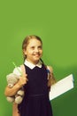 Girl with braids and happy face. Pupil holds blue book Royalty Free Stock Photo