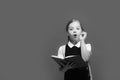 Girl with braids having idea. Pupil holds big blue book Royalty Free Stock Photo