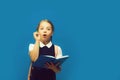 Girl with braids having idea. Pupil holds big blue book Royalty Free Stock Photo