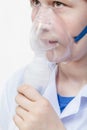 Girl breathes with face mask of jet nebulizer