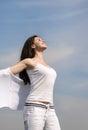 Girl breathes in fresh air on a blue sky background.