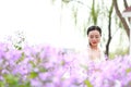 Girl bride in wedding dress with elegant hairstyle in Orychophragmus violaceus flower field Royalty Free Stock Photo