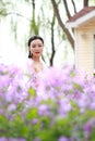 Girl bride in wedding dress with elegant hairstyle in Orychophragmus violaceus flower field Royalty Free Stock Photo