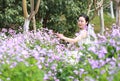 Girl bride in wedding dress with elegant hairstyle, with white wedding dress in Orychophragmus violaceus flower field Royalty Free Stock Photo