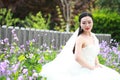 Girl bride in wedding dress with elegant hairstyle, with white wedding dress Sitting on the bench next to the fence Royalty Free Stock Photo