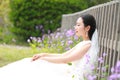 Girl bride in wedding dress with elegant hairstyle, with white wedding dress Sitting Leaning against the fence Royalty Free Stock Photo