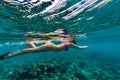 Girl snorkeling in ocean with turtles on blue water background