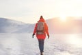 Girl in bright clothes and a backpack walking on snow