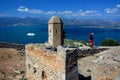 Girl in bright clothes taking photos of Palamidi Castle, Nafplio, Greece Royalty Free Stock Photo