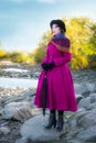 Girl in a bright crimson coat looks into the distance