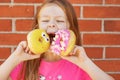 A girl with bright donuts in her hands is making faces