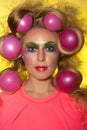 Girl with bright makeup and hair balls on yellow background