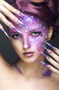 Girl with bright purple creative makeup with crystals and long nails. Beauty face.