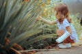 Girl with a Broken Arm in Orthopedic Plaster Enjoying Plants