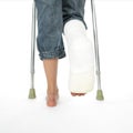 Girl with a broken leg walking on crutches Royalty Free Stock Photo