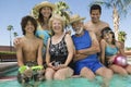 Girl (10-12) with brother (13-15) parents and grandparents at swimming pool portrait. Royalty Free Stock Photo