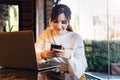 Girl browsing social networks on smartphone while sitting cafe. Blogger chatting with followers oncell phone coffee shop.Lifestyle Royalty Free Stock Photo