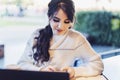 Girl browsing social networks on smartphone while sitting cafe. Blogger chatting with followers oncell phone coffee shop.Lifestyle Royalty Free Stock Photo