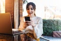 Girl browsing social networks on smartphone while sitting cafe. Blogger chatting with followers oncell phone coffee shop.Lifestyle Royalty Free Stock Photo