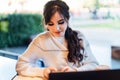 Girl browsing social networks on smartphone while sitting cafe. Blogger chatting with followers oncell phone coffee shop.Lifestyle Royalty Free Stock Photo