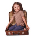 Girl brunette baby sitting in a suitcase for travel isolated on Royalty Free Stock Photo