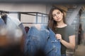 The girl in the clothing store chooses a denim jacket, chose and pressed to her. Royalty Free Stock Photo