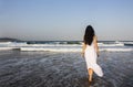 Girl brunette in white dress entering the Indian Ocean. Royalty Free Stock Photo