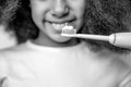 Girl brushes her teeth an electric toothbrush close-up. Little cute african american girl brushing her teeth. Healthy Royalty Free Stock Photo