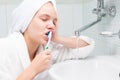 Girl brushes her teeth in the morning in the bathroom over the sink