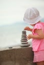 Girl is building a construction from pebble stones Royalty Free Stock Photo