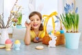 Girl in bunny ears on. Holyday morning at the table with Easter eggs basket. Kids celebrating Easter. Festive decoration Royalty Free Stock Photo