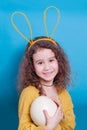 Girl with bunny ears with ostrich egg on a colored background Royalty Free Stock Photo