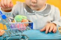 A girl with bunny ears puts dyed Easter eggs in a cart and delivers them for Easter Royalty Free Stock Photo