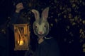 Girl in a bunny mask with the lantern at night. Halloween party