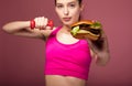 Girl with a burger posing in the gym