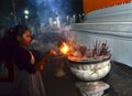 Girl burning incense at temple