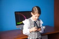 Girl in a business suit stands at the computer and talks on the phone Royalty Free Stock Photo