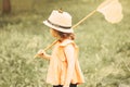Girl with butterfly net having fun at field. Child catching butterflies and exploring nature. Summer concept Royalty Free Stock Photo