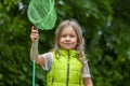 Girl with butterfly net, serious expression, emotional portrait of a child. Royalty Free Stock Photo