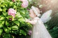 girl with butterfly wings in hydrangea park Royalty Free Stock Photo