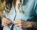 Girl buttoning buttons on her blouse close-up Royalty Free Stock Photo