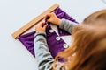 Girl buttoning a montessori frame to develop the dexterity of her fingers Royalty Free Stock Photo
