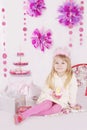 Girl with cake at pink decoration birthday party