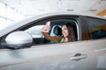 A young girl chooses a new car for herself. Buying a new car. Royalty Free Stock Photo